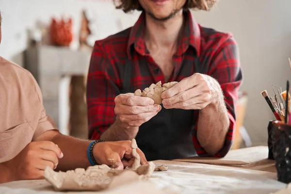 Rzemieślnik w fartuchu uczy młodych ludzi ze specjalnymi potrzebami przygotowywania talerzy — Zdjęcie stockowe