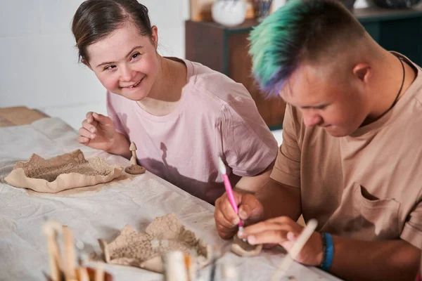 Ragazza con la sindrome di Down sorridente e guardando l'insegnante mentre il suo fidanzato — Foto Stock