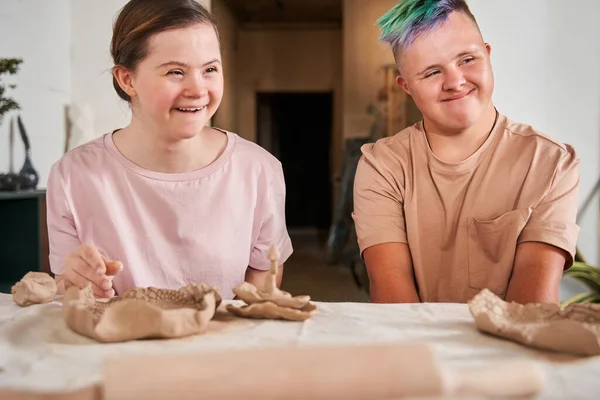 Een paar van de down syndroom mensen kijken weg en glimlachen vrolijk — Stockfoto