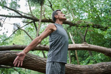 Kıdemli adam temiz havadaki eğitimin tadını çıkarırken kollarını ve gözlerini açtı.