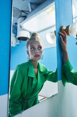 Banyoda vakit geçirirken aynaya ciddi ciddi bakan bir kadın.