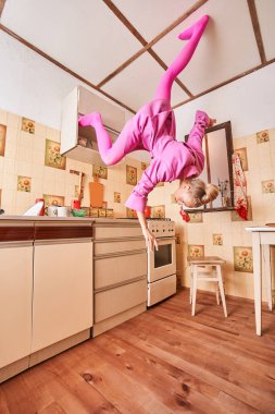 Kadın model, poz verirken eski mutfağın etrafında dolanıyor.