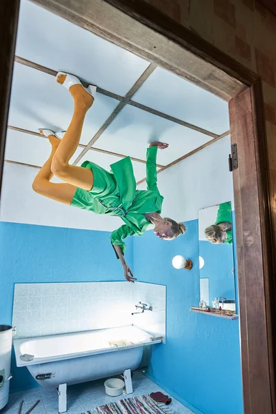 Fashion model met groene jas poseren aan het plafond in de badkamer — Stockfoto