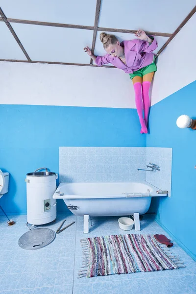 Ragazza che indossa abiti luminosi posa alla testa soffitto sopra i talloni in bagno — Foto Stock