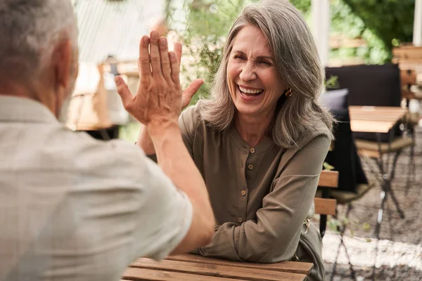 Senior woman giving five to her beloved husband while discussing something — Stock Photo, Image