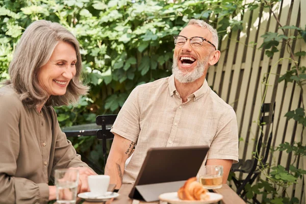 Couple laughing out loud while chatting via video call at the tablet — Stockfoto