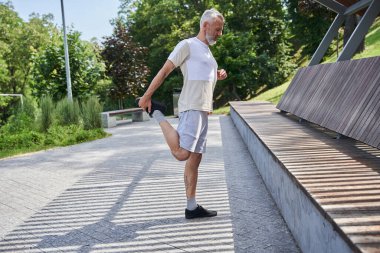 Man stretching, exercising and feeling calm while spending time at the summer nature