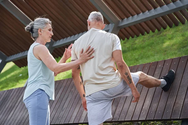 Frau greift ihrem Mann auf den Rücken und hilft ihm — Stockfoto