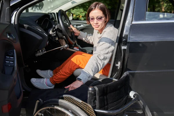 Young disabled person getting out from the wheelchair in her car — Φωτογραφία Αρχείου