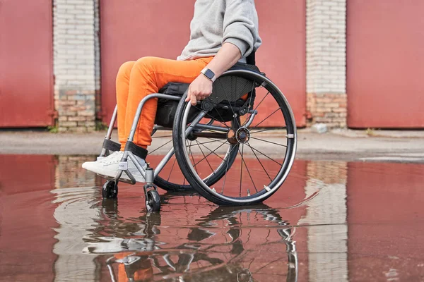 Žena se ztrátou funkce nohy sedí na invalidním vozíku a těší se z počasí — Stock fotografie