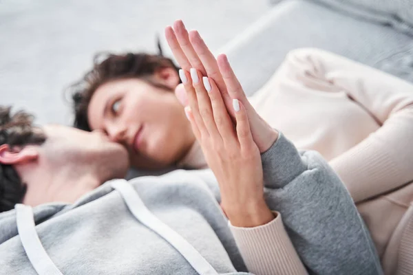 Hombre tocando mano a mano de su encantadora mujer mientras la mira a los ojos — Foto de Stock