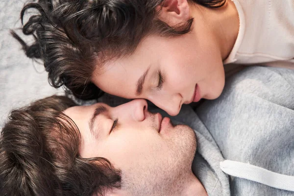 Mujer tendida con los ojos cerrados y sintiendo felicidad con su hombre — Foto de Stock