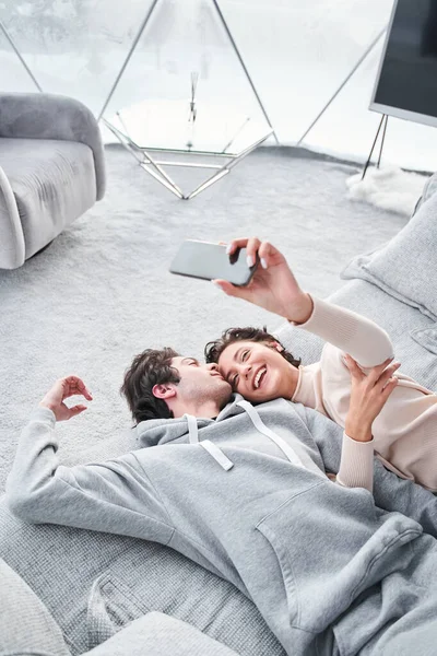 Романтическая влюбленная пара позирует для фото на смартфоне, пока лежит — стоковое фото