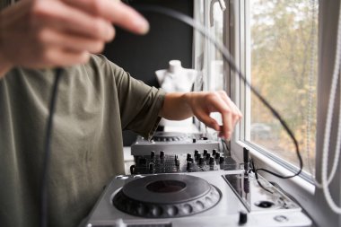 DJ pencerenin yanında duruyor ve işe hazırlanıyor.