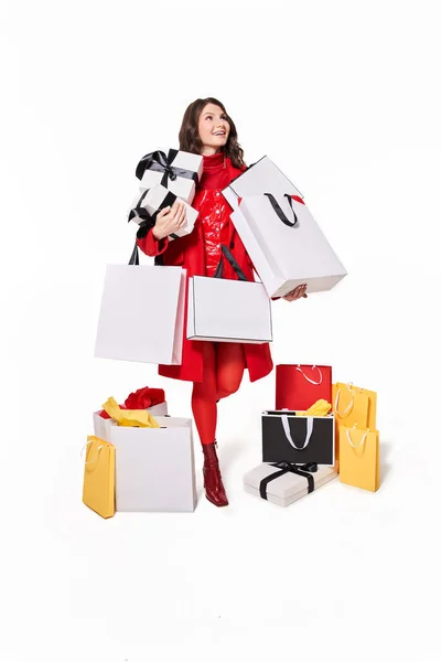 Woman with purchases and shopping bags smiling while looking up — Stock Photo, Image