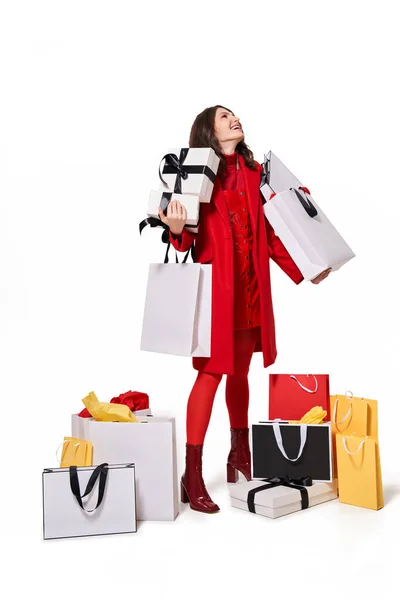 Woman looking up while holding a lot of purchases — Stock Photo, Image