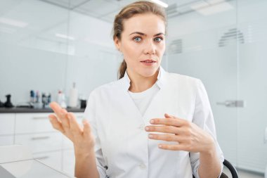 Kadın dişçi hastasıyla internet bağlantısı üzerinden iletişim kuruyor.