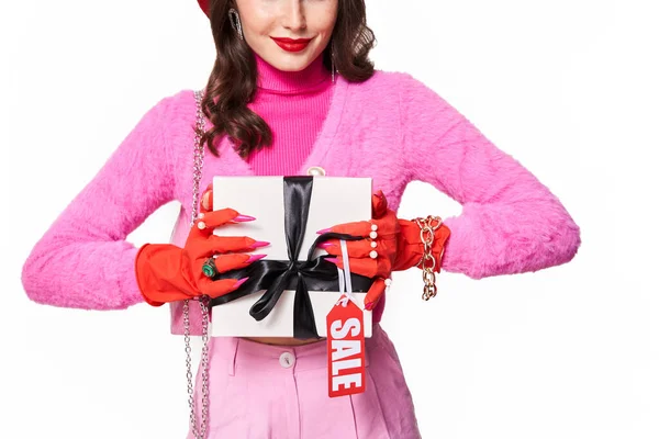 Frau in pinkfarbener Kleidung zeigt der Kamera weiße Geschenkbox — Stockfoto