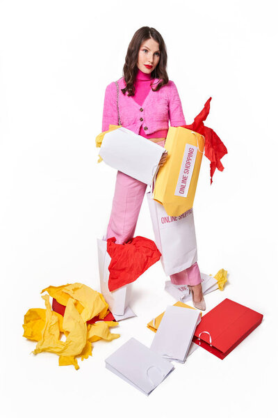 Woman looking away while holding many empty paper bags