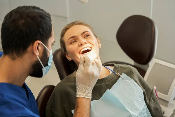 Paciente femenina sentada en la clínica durante el examen de sus dientes —  Fotos de Stock