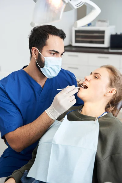 Paciente bastante femenina sentada en la clínica durante el examen de sus dientes —  Fotos de Stock