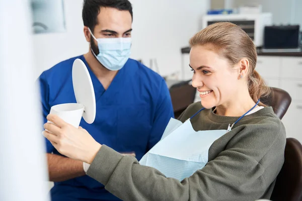 Espelho de retenção do dentista enquanto verifica o resultado final — Fotografia de Stock