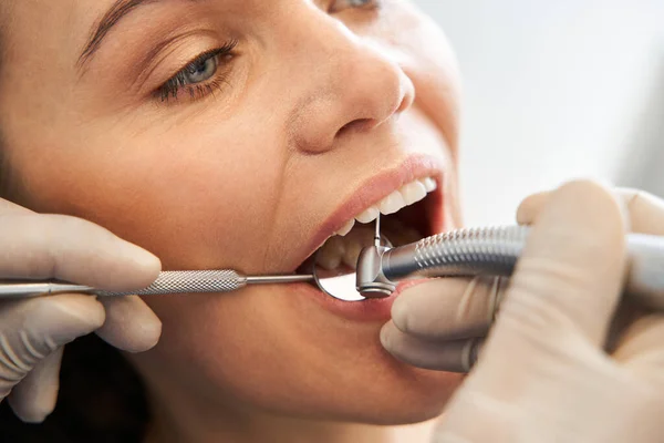 Dentista comenzando operación común de limpieza de la boca femenina — Foto de Stock