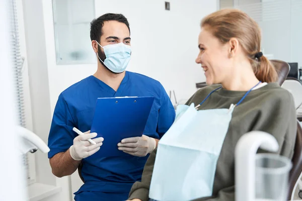 Doktorn diskuterar något med sin kvinnliga söta patient. — Stockfoto