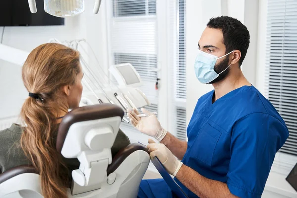 Doctor con máscara de protección diciendo algo a su cliente —  Fotos de Stock