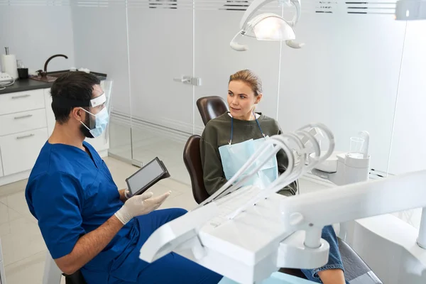 Paciente e dentista estão discutindo a imagem dos dentes no tablet digital — Fotografia de Stock