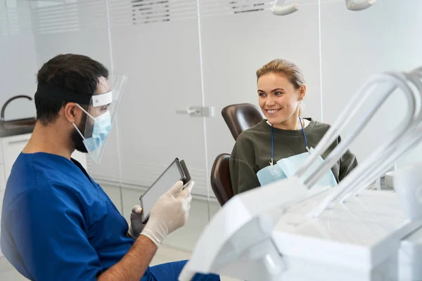 Homem dentista conversando com sua mulher paciente em cirurgia odontológica — Fotografia de Stock