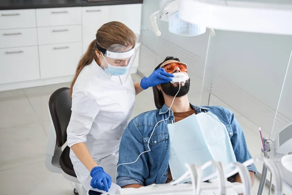Dentista que sostiene el dispositivo dental para fijar los dientes — Foto de Stock