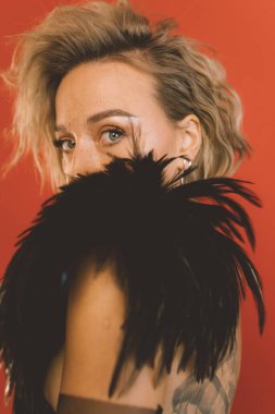 Omuzlarının üzerinden kameraya bakan kadın.