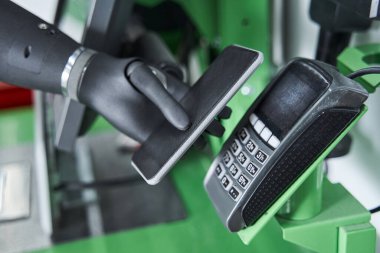 İmplant elli tüketici akıllı telefonu kasiyer-makine üzerinde tutuyor