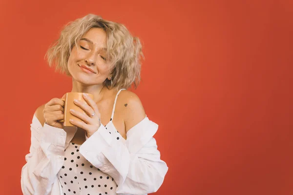 Frau schließt Augen und hält Tasse heißen Kaffee in der Hand — Stockfoto