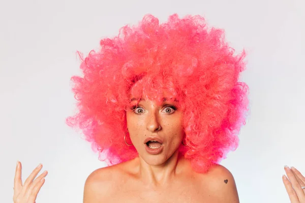 Mujer vestida con peluca rizada rosa manteniendo la boca abierta — Foto de Stock