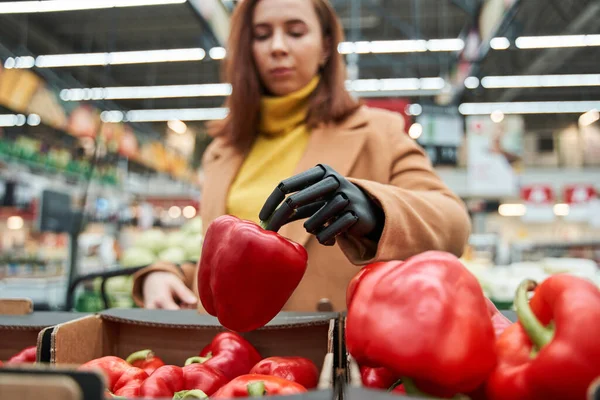 Vrouw met prothese arm met rode peper in de hand — Stockfoto