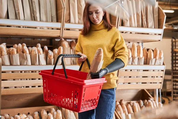 Fille avec bras de prothèse en choisissant le pain ou la baguette — Photo