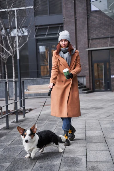 Woman with prosthesis arm holding a leash of her corgi dog — Stock Photo, Image