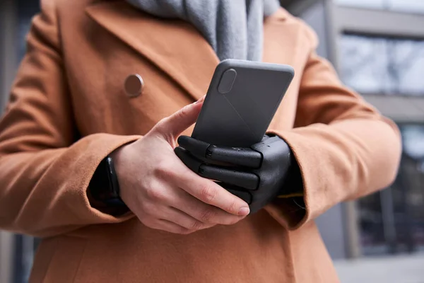 Woman with artificial limb holding her smartphone — Stock Photo, Image