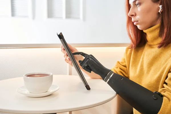 Femme avec prothèse bras livre de lecture sur tablette numérique — Photo
