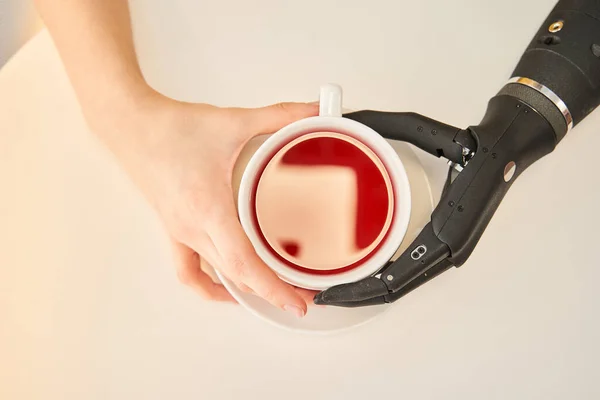 Женщина с искусственной конечностью пьет горячий чай в столовой — стоковое фото