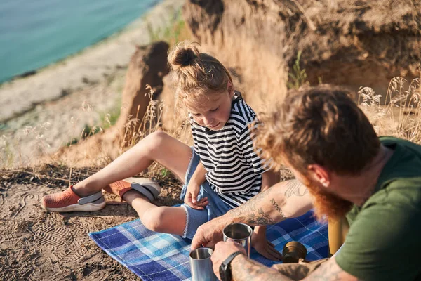 Twee personen die genieten van warme dranken terwijl ze aan de natuur zitten — Stockfoto