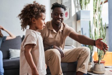 Anne ve babası birlikte oynarken kızına bir şeyler anlatıyor.