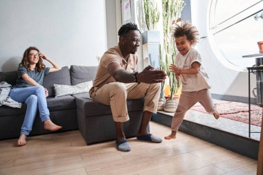 Çok mutlu evli çift çocuklarıyla oturma odasında en sevdikleri oyunu oynuyorlar.