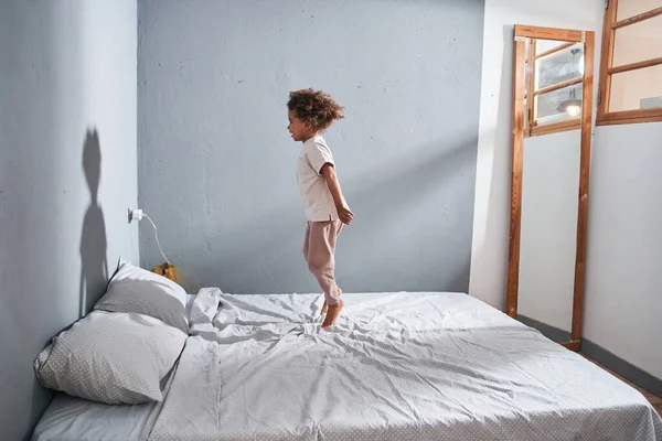 Meisje springen op het bed en het gevoel plezier terwijl het doorbrengen van tijd alleen op de slaapkamer — Stockfoto