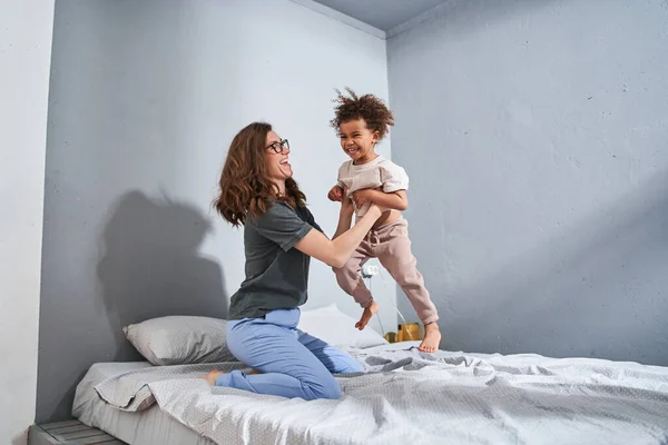 Chica jugando con su madre amigable mientras disfruta del tiempo libre —  Fotos de Stock