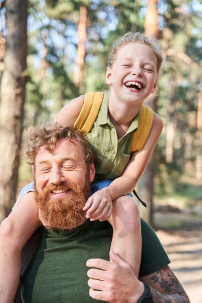 Girl on neck of her father walking in forest — Stock Photo, Image