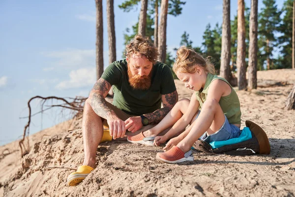 Father and daughter drawing on sand on coast — Stock Photo, Image