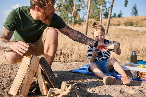 Man die vuur maakt en taart geeft aan dochter — Stockfoto